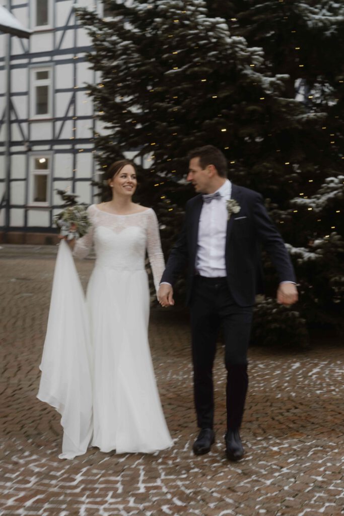Hochzeit im Schnee auf Weihnachtsmarkt mit Weihnachtsbaum Hochzeitsbegleitung Fotografin.