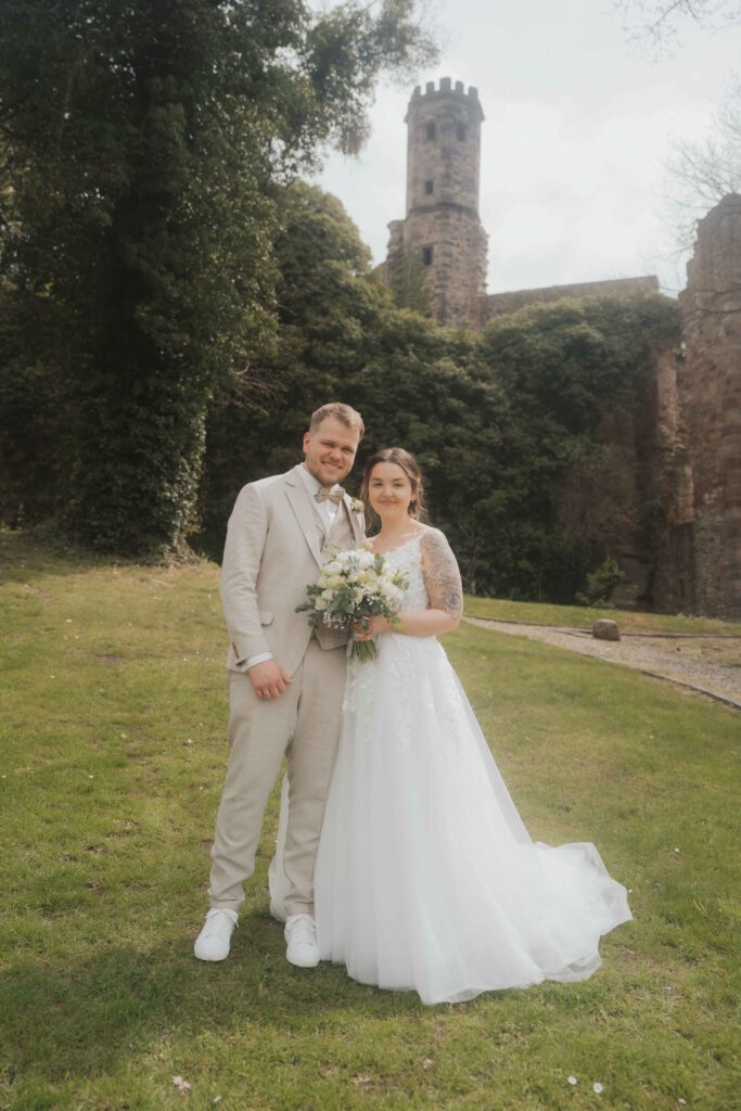 Brautpaar unter einem Blätterdach im Park Göttingen, während goldenes Sonnenlicht durch die Bäume fällt, fotografiert von Hochzeitsfotografin Göttingen